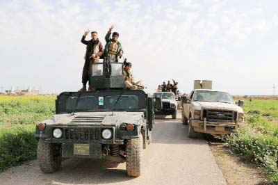Iraqi fighters flash the victory sign during fighting to re-take control of the city of Basheer, some 20 kilometres south of the city of Kirkuk, on Friday.