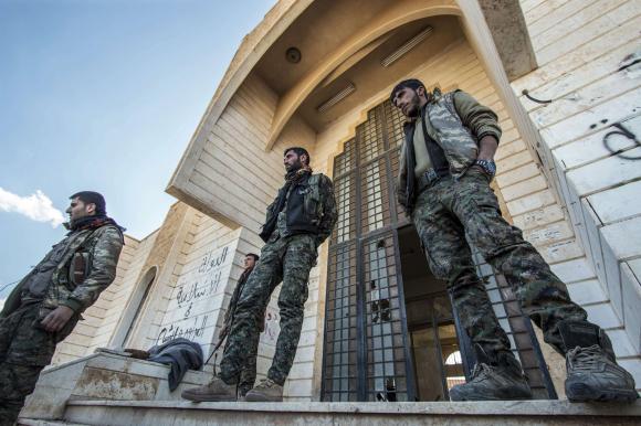Kurdish People's Protection Units (YPG) fighters stand outside one of the Islamic State headquarters in Tel Hamis in northeast Syria, after the YPG took control of the area March 1, 2015. Credit: ReutersRodi Said
