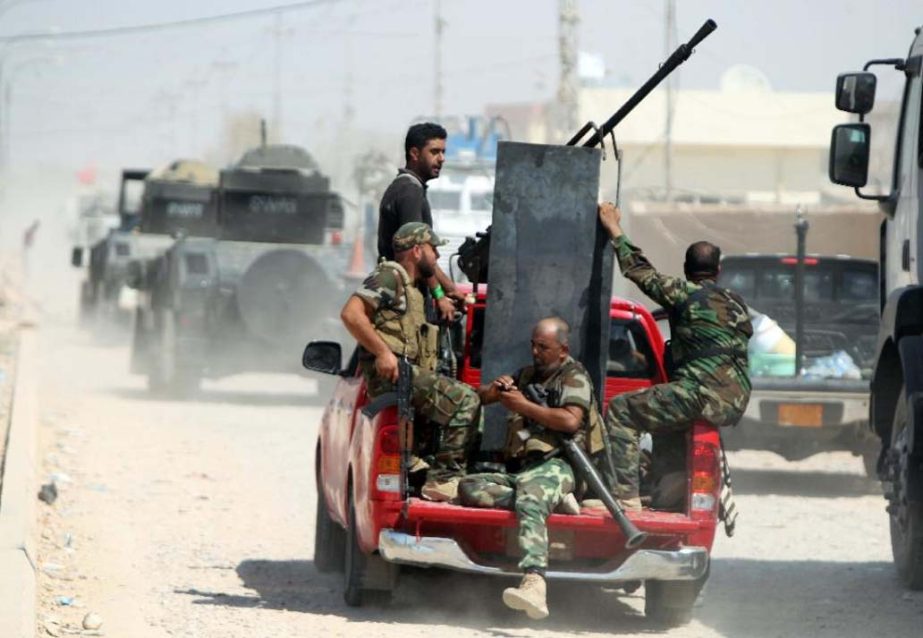 Iraqi Shiite militia fighters ride in a truck after pushing back Islamic State group militants on the road between Amerli and Tikrit.