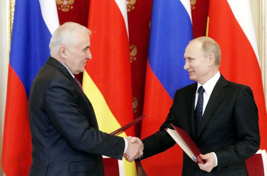 Russian President Vladimir Putin Â® and the leader of Georgia's breakaway region of South Ossetia, Leonid Tibilov, shake hands as they exchange documents at a signing ceremony following their meeting at the Kremlin in Moscow.