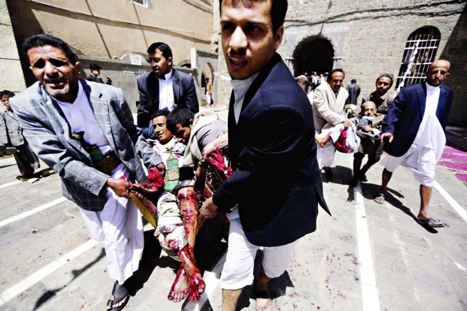 Yemenis carry a body of a man killed in a bomb attack in a mosque in Sanaa, on Friday. Triple suicide bombers hit a pair of mosques crowded with worshippers causing heavy casualties, according to witnesses.