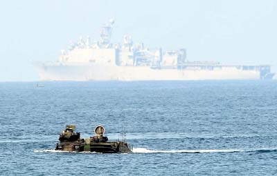Two US marine assault vehicles manuever in high seas before USS Germantown in joint naval exercises with the Philippines in the South China Sea