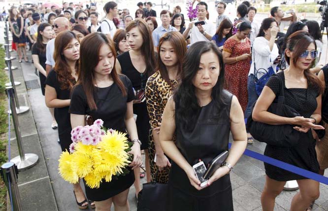 People queue up to pen their condolences as they mourn the passing of former prime minister Lee Kuan Yew outside the Istana in Singapore on Monday.