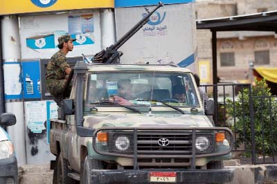 Shiite Huthi militiamen sit on a pick-up truck mounted with a heavy machine-gun in Sanaa.