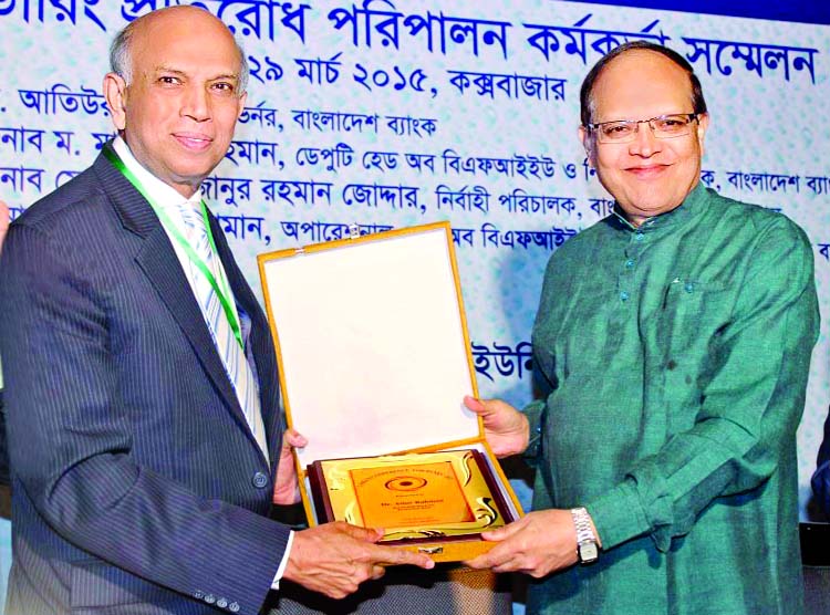 Aminul Islam, Additional Managing Director and CAMLCO of Bank Asia, handing over a crest to Bangladesh Bank Governor Dr Atiur Rahman at the inaugural session of CAMLCO Conference-2015 at Cox's Bazar on Friday.