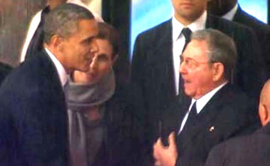 US President Barack Obama, left, shakes hands with Cuban President Raul Castro in South Africa.