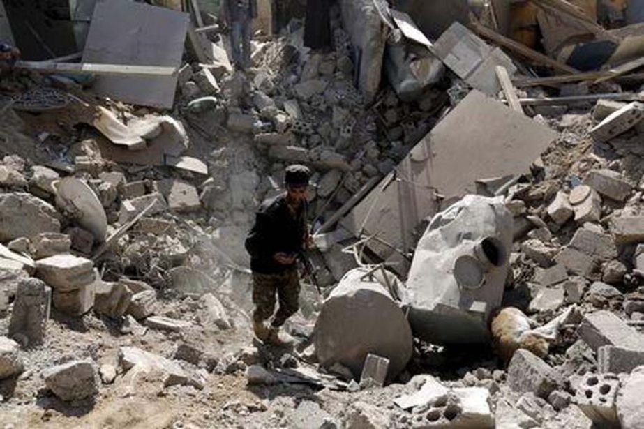 A police trooper walks in a creater caused by an air strike on houses near Sanaa Airport .