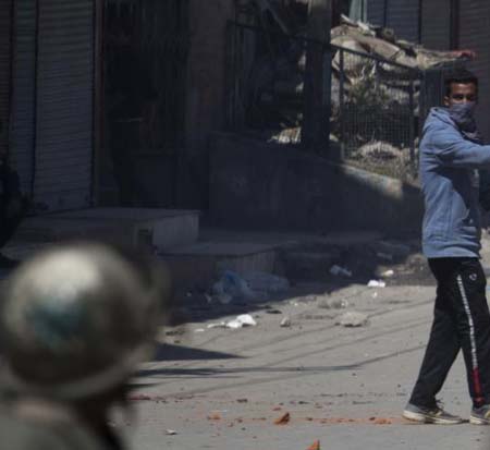 Protesters hurl rocks at policemen during a demonstration in Srinagar on Friday.