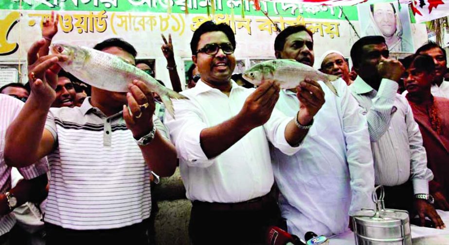 DSCC mayoral candidate Sayeed Khokan campaigning with fresh â€˜Hilsaâ€™ fish in city's Dhupkhola area on Saturday.