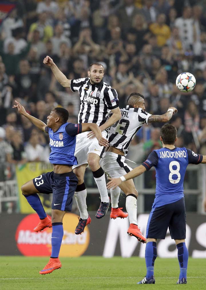 Monaco's Anthony Martial (left) goes for a header with Juventus players Giorgio Chiellini and Arturo Vidal (right) during the Champions League quarterfinal first leg soccer match between Juventus and Monaco at the Juventus stadium in Turin, Italy on Tue