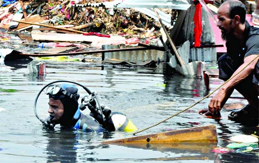 Fire fighters continue searching in a bid to rescue more bodies as two-storied tin shed shanty caved-in at Boubazar Jhilpar area East Rampura on Wednesday.