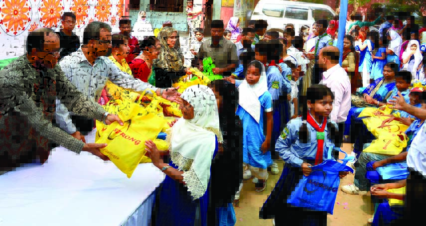 Deputy Commissioner of Dhaka District Tofazzal Hossain Mia distributing educational materials among the students of Mahuttuli Government Primary School in Armanitola area in the city on Saturday.