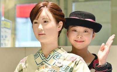 A department store employee poses with humanoid ChihiraAico clad in a Japanese kimono in Tokyo.