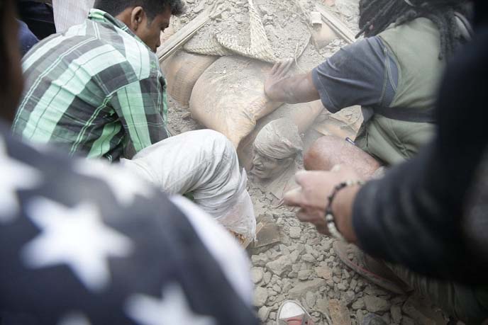 A man is buried up to his neck in rubble as the rescue teams attempt to dig him free from the collapsed building in the capital of Nepal.