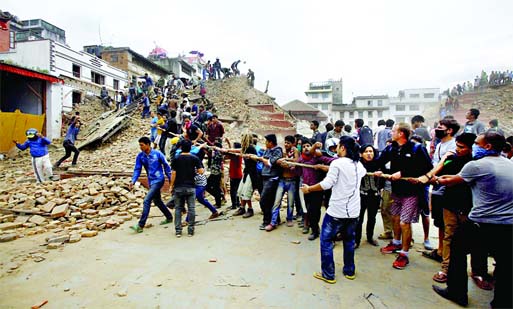 Teams of locals and volunteers helping to heave away huge pieces of debris from homes, business and offices left by the earthquake. (Picture also on Page 14) Internet