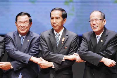 From left to right, Cambodia's Prime Minister Hun Sen, Indonesia's President Joko Widodo, and Philippine's President Benigno Aquino III join their hands during the opening ceremony of the 26th ASEAN Summit in Kuala Lumpur, Malaysia on Monday