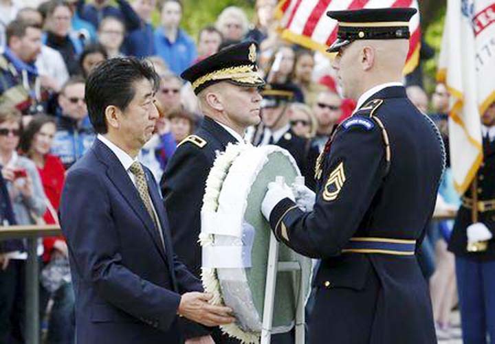 Japanese Prime Minister Shinzo Abe (L) places a wreath at the Tomb of the Unknowns in Arlington National Cemetery in Washington.