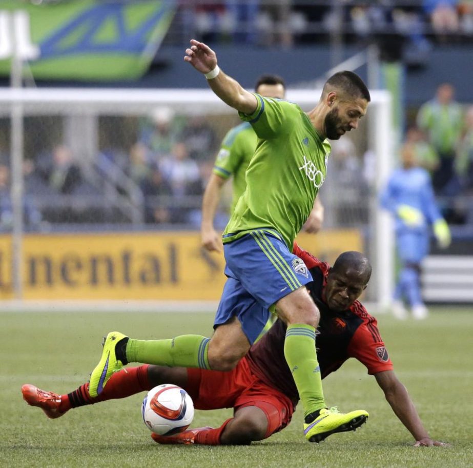 Seattle Sounders' Clint Dempsey runs with the ball as Portland Timbers' Darlington Nagbe goes down in the first half of an MLS soccer match in Seattle on Sunday.