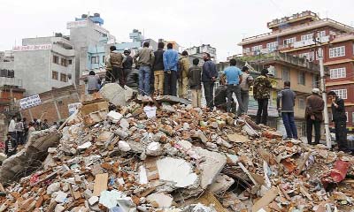 People look at a rescue site while standing on the wreckage of houses ruined after Saturday's earthquake in Kathmandu, Napal on Thursday.