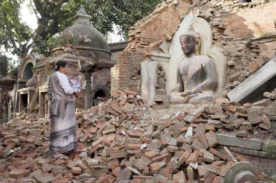 A Nepalese woman offers morning prayers at a temple damaged in last Saturday's earthquake in Bhaktapur, Nepal on Saturday.