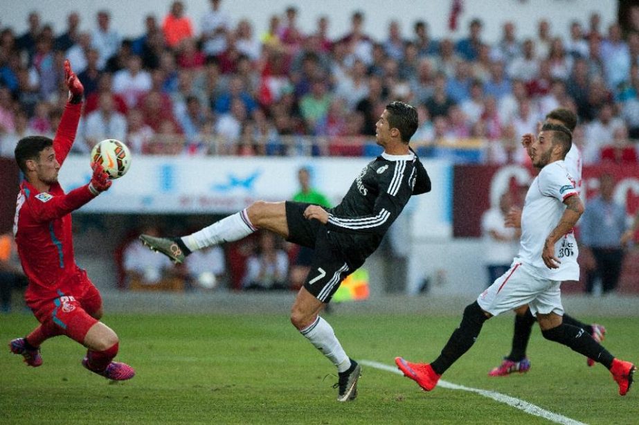 Real Madrid's Portuguese forward Cristiano Ronaldo (C) scores past Sevilla's goalkeeper Sergio Rico (L) during the Spanish league football match in Sevilla on Saturday.