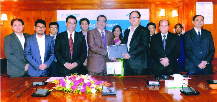 Sk Golam Mohammad, General Manager, Establishment Division of Pubali Bank Ltd and Sazzad Alam, Deputy Director, Direct Sales of Grameenphone Ltd sign an agreement for business solutions service at the bank's head office recently. Md Abdul Halim Chowdhury