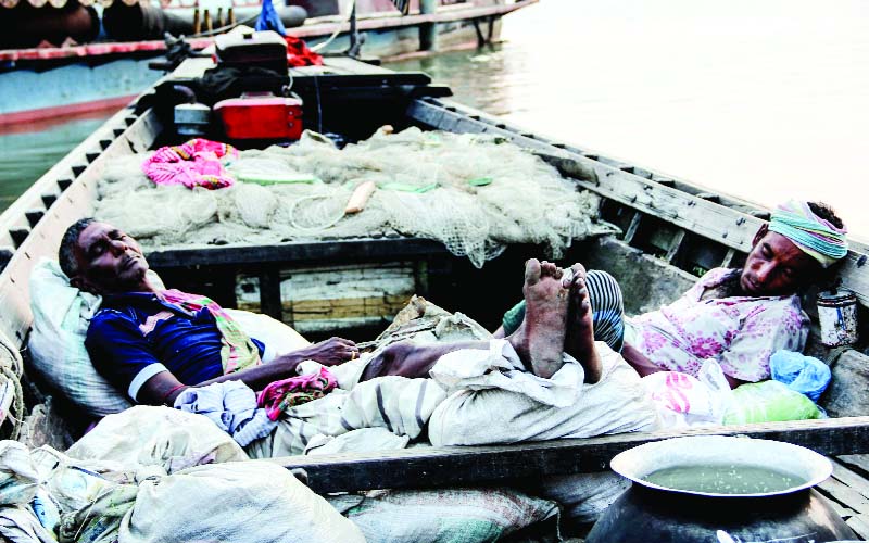 SIRAJGANJ: Two fishermen at Hartpoint area have fallen asleep in their boats after fishing in the whole night in Jamuna River . This picture was taken yesterday morning.