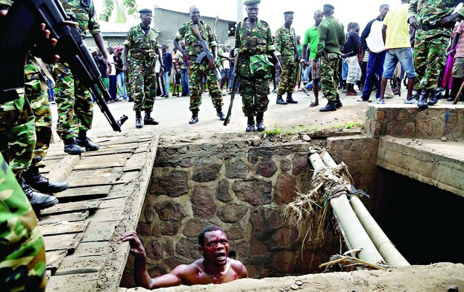 Jean Claude Niyonzima, a suspected member of the ruling party's Imbonerakure youth militia, pleads with soldiers to protect him from a mob of demonstrators after he emerged from hiding in a sewer in the Cibitoke district of Bujumbura, Burundi.