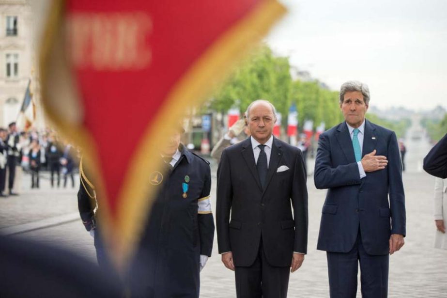 U.S. Secretary of State John Kerry, accompanied by French Foreign Minister Laurent Fabius, (centre) participates in a wreath laying ceremony at the Tomb of the Unknown Soldier in Paris, France on Friday, during France's 70th anniversary of V-E Day.