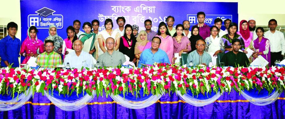 A Rouf Chowdhury, Chairman of Bank Asia, poses with the scholarship recipients students of Sirajdikhan, Malkhanagar, Baligaon, Nimtola, Paragram in Munshiganj and Rohitpur of Keraniganj Upazila on Friday as part of its corporate social responsibility.