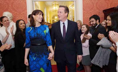 British Prime Minister David Cameron and his wife Samantha are applauded upon entering 10, Downing Street in London.