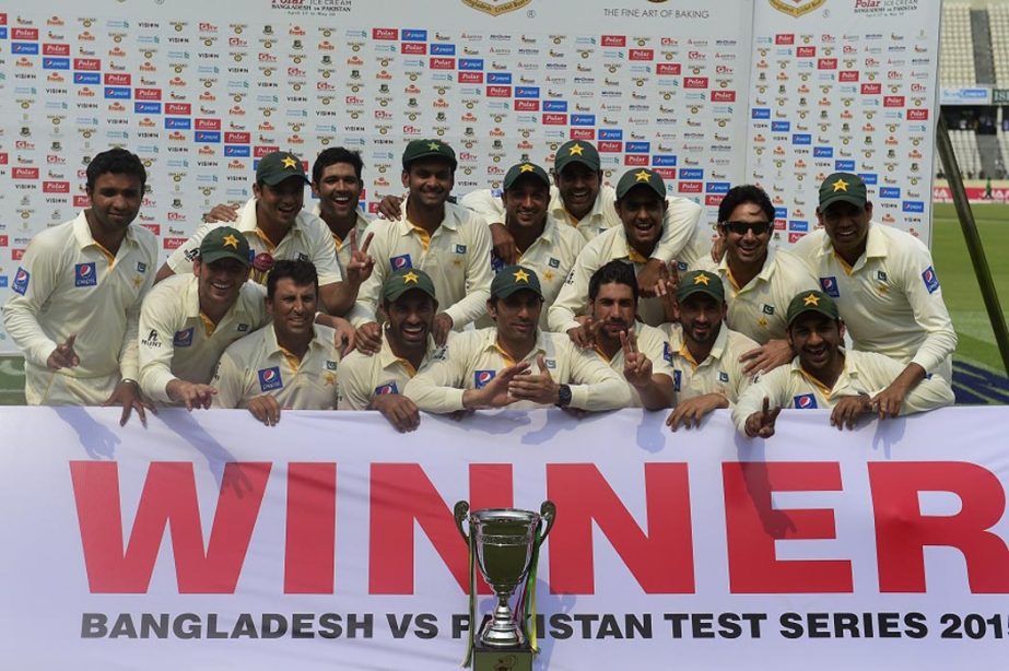 Pakistan cricketers pose for a group photograph with the tournament trophy following the presentation ceremony after the fourth day of the second cricket Test match between Bangladesh and Pakistan at the Sher-e-Bangla National Cricket Stadium in Mirpur on