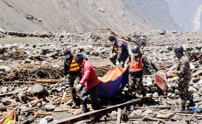 Rescue personnel retrieve a body from the wreckage of the village of Langtang .