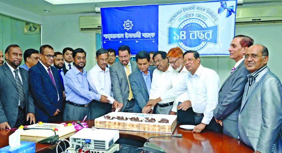 AK Azad, Chairman of Shahjalal Islami Bank Ltd, celebrating its 14th Anniversary by cutting cake at the head office on Sunday. Vice-Chairmen of the Board Mohammad Younus and Md Abdul Barek, Directors Akkasuddin Mollah, Engineer Md Towhidur Rahman, Md Sana