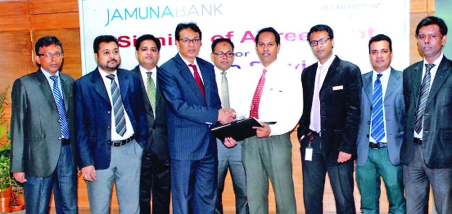 AKM Saifuddin Ahamed, Deputy Managing Director of Jamuna Bank Limited and Khairul Anam, Sr Manager, Sales and Business Development of Ocean Paradise, sign an agreement at the bank's head office recently. Executives of the bank and its Credit Card holders