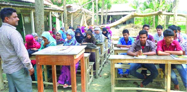 KOTIADI(KISHOREGANJ):Students of Charadarsha College in Kotiadi Upazila are attending classes under the open sky as the only tin -shed house was damaged by recent nor'wester . This picture was taken on Sunday.