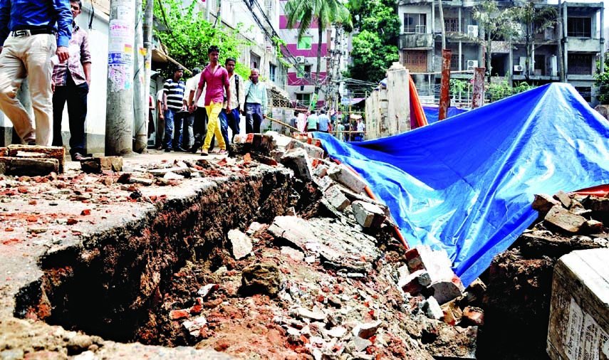 Boundary wall and a portion of Purana Paltan Lane in city's Bijoynagar area collapsed while piling work continues for building construction on Monday.