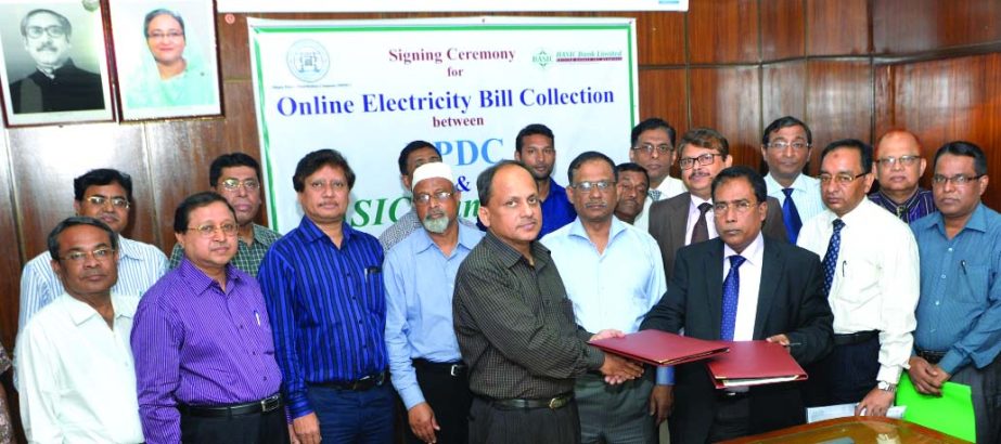 Khondoker Md Iqbal, Managing Director of BASIC Bank Limited and Md Munir Chowdhury, Company Secretary of Dhaka Power Distribution Company Limited sign MoU at the conference room of DPDC on Wednesday. From now DPDC clients will be able to pay their electri