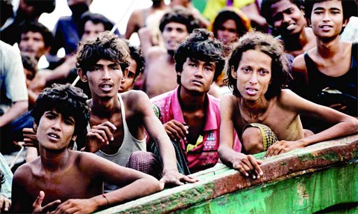 Rohingya migrants sit on a boat drifting in Thai waters off the southern island of Koh Lipe. The vessel is crammed with scores of people, including many young children. AFP Photo