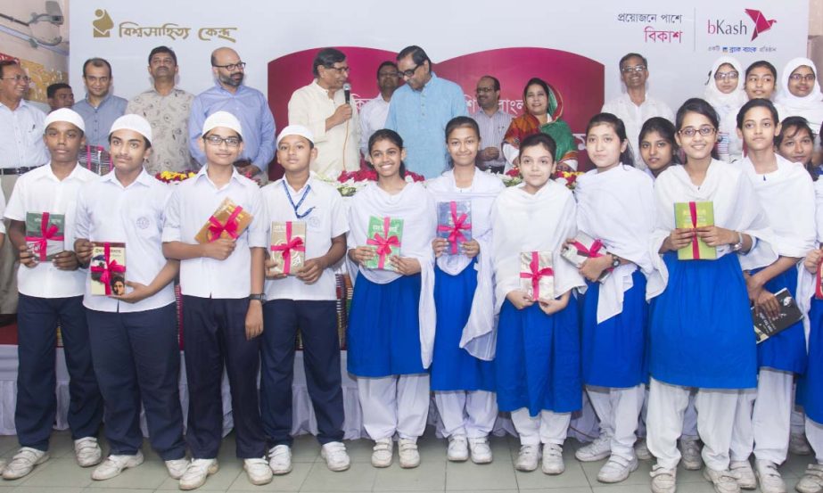 Civil Aviation and Tourism Minister Rashed Khan Menon, MP and Bishwo Shahitto Kendro Chairman Abdullah Abu Sayeed pose with the students of Motijheel Ideal School and College at a "country-wide book reading program" at the school premises on Saturday.