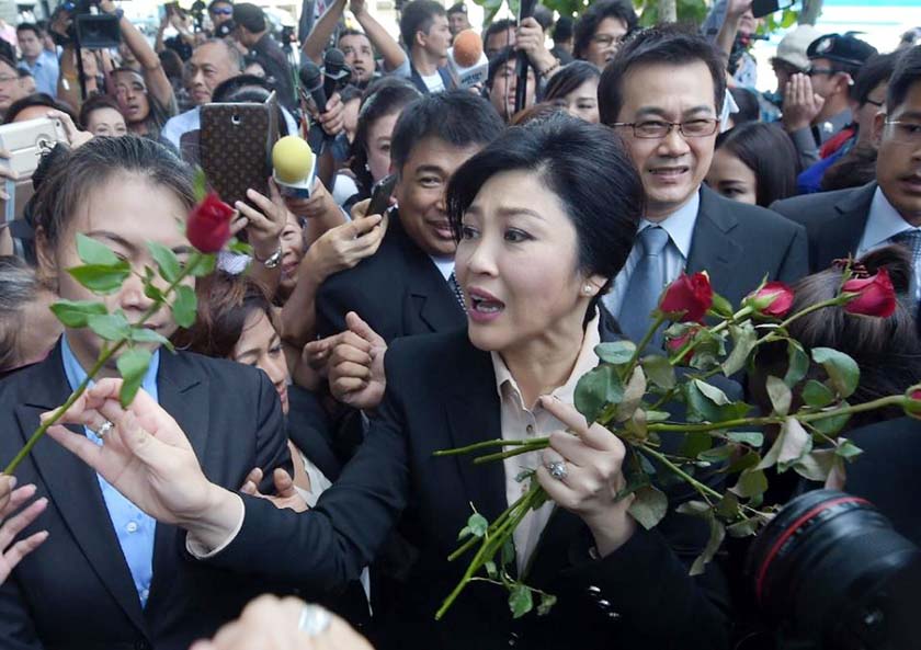 Thailand's former Prime Minister Yingluck Shinawatra, center, walks through supporters as she leaves the Supreme Court in Bangkok, Thailand on Tuesday.