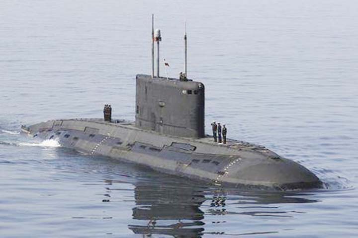 Iranian military personnel stand on a submarine during a naval parade on the last day of the Velayat-90 war game in the Sea of Oman near the Strait of Hormuz in southern Iran .