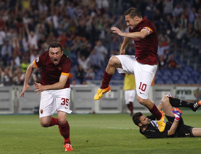 Roma's Vasileios Torosidis (left) celebrates with teammate Francesco Totti after scoring as Udinese's goalkeeper Orestis Karnezis (right) lies on the pitch during a Serie A soccer match between Roma and Udinese, at Rome's Olympic stadium on Sunday.