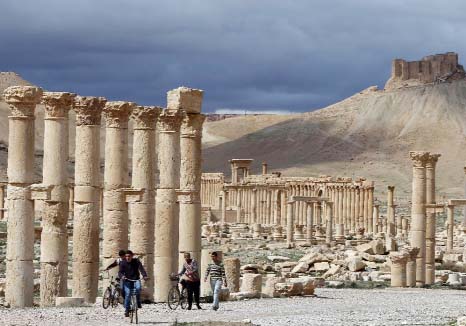 Syrian citizens riding their bicycles in the ancient oasis city of Palmyra.