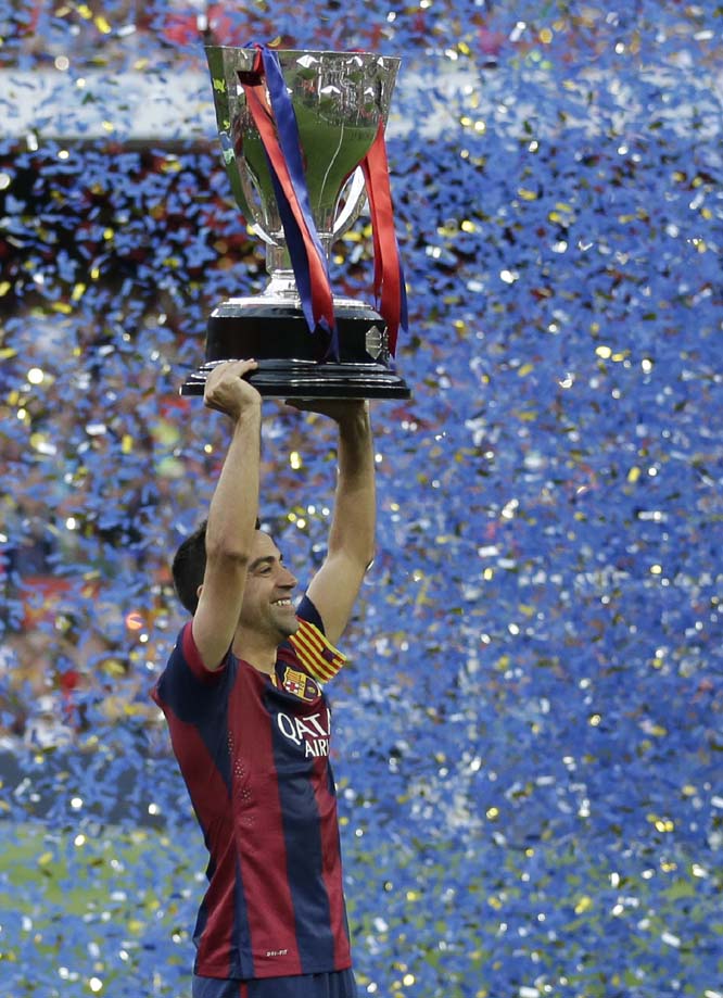 FC Barcelona's Xavi Hernandez holds up the trophy after winning the Spanish League title, at the end of their Spanish La Liga last round soccer match against Deportivo Coruna at the Camp Nou stadium in Barcelona, Spain on Saturday.