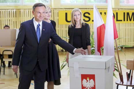 Presidential candidate of the Law and Justice Party Andrzej Duda (L) casts his vote next to his wife Agata and daughter Kinga at a polling station in Krakow, Poland.