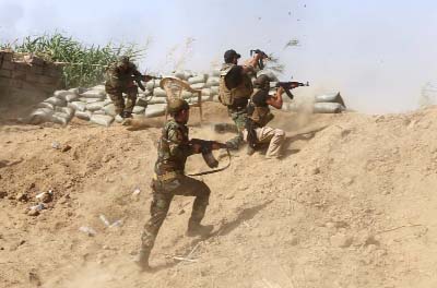 Iraqi Sunni fighters battling Islamic State (IS) group jihadists alongside government forces fire their weapons on the outskirts of Iraq's Baiji oil refinery .