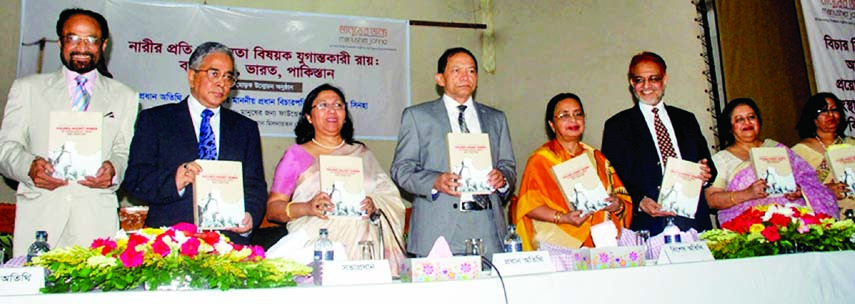 Chief Justice Surendra Kumar Sinha along with other distinguished guests holds the copies of a book titled 'Epoch-making verdict on violence against women: Bangladesh, India, Pakistan' second part at its cover unwrapping ceremony organized by Manusher J