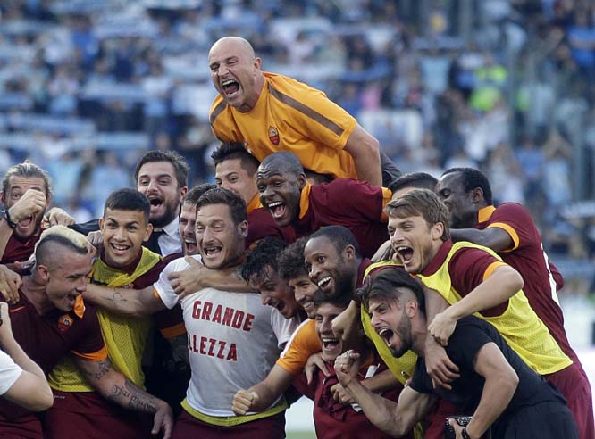 Roma's Francesco Totti (center) wears a jersey reading in Italian ' La Grande Bellezza ' (The Great Beauty) as he celebrates with his teammates at the end of a Serie A soccer match between Lazio and Roma at Rome's Olympic Stadium on Monday. Roma won