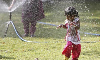 A child plays in front of a water sprinkler to cool of on a hat summer day in Nehru Zoological Park in Hyderabad, India.